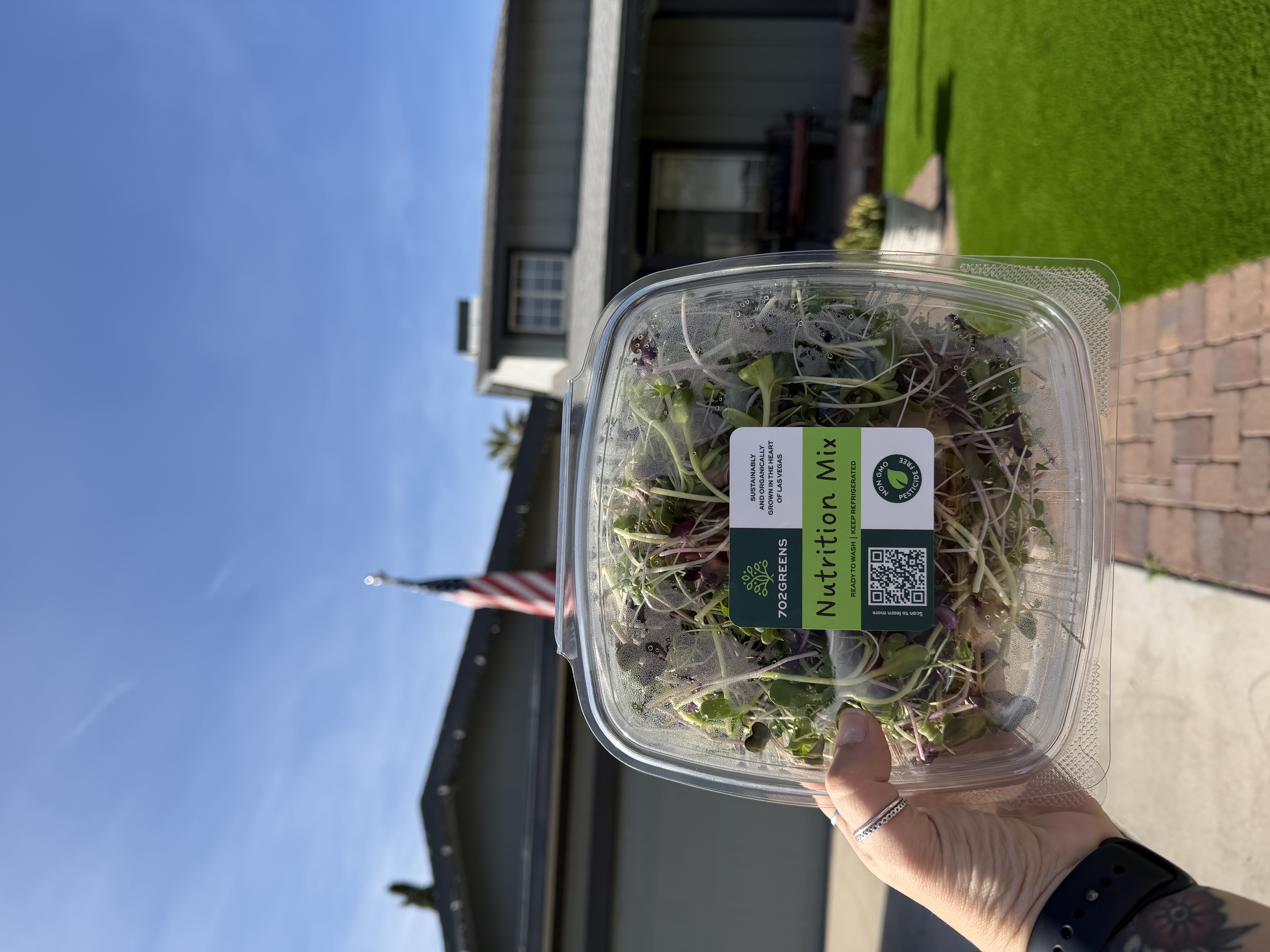 702Greens member holding fresh microgreens box